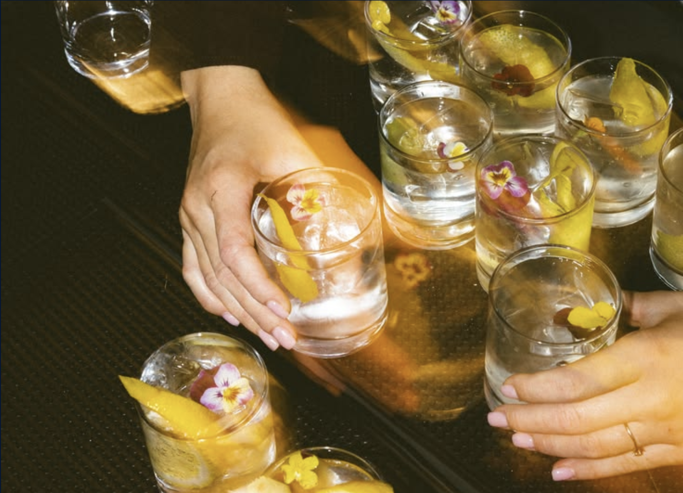 Cocktails garnished with citrus and flowers
